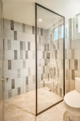 a bathroom with a glass shower with a toilet at Zhudeng 1965 Hotel in Green Island