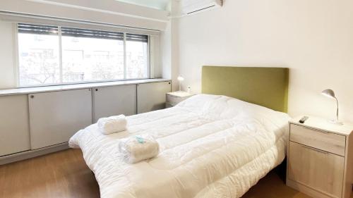 Un dormitorio con una gran cama blanca y una ventana en CORD0301 Gran Studio a metros del Obelisco en Buenos Aires