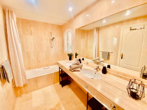 a bathroom with a sink and a large mirror at Elviria Apartment in Marbella