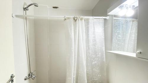 baño con ducha con cortina blanca en CORD0301 Gran Studio a metros del Obelisco en Buenos Aires