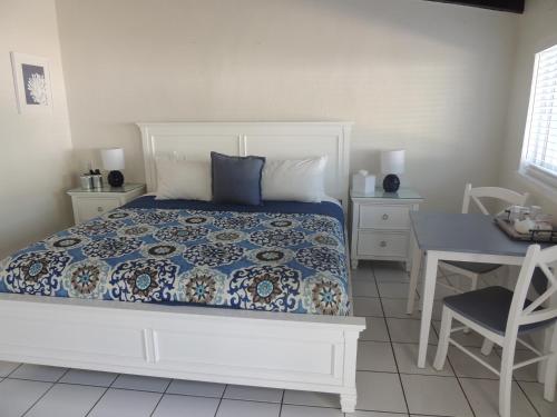 a bedroom with a bed and a table and a chair at Sands of Islamorada in Islamorada