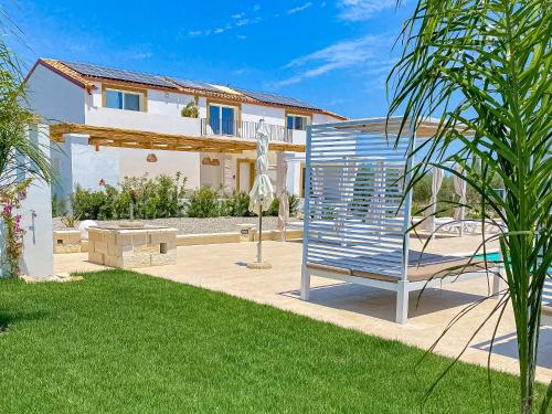 een tuin met een bank en een huis bij Dimora Calauriia - Adults Only in Noto