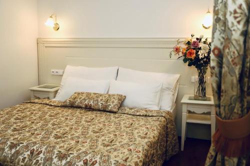 1 dormitorio con 1 cama y un jarrón de flores en Zlatý Sloup, en Karlovy Vary