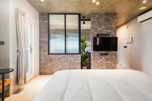 a bedroom with a white bed and a stone wall at Zhudeng 1965 Hotel in Green Island