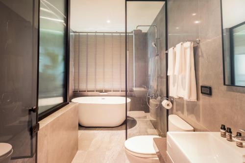 a bathroom with a tub and a toilet and a sink at Zhudeng 1965 Hotel in Green Island