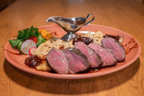 a plate of meat and vegetables on a table at David Wellness Hotel in Harrachov