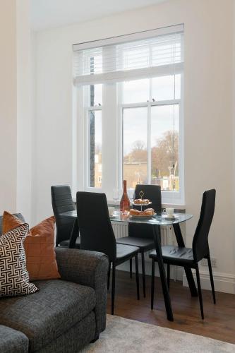 a dining room with a table and chairs and a window at Chelsea Apartment Stamford Bridge, King's Road & Fulham Road in London