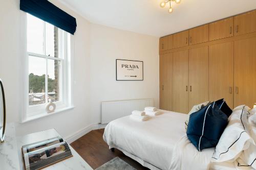 a white bedroom with a bed and a window at Luxury Chelsea Flat in London