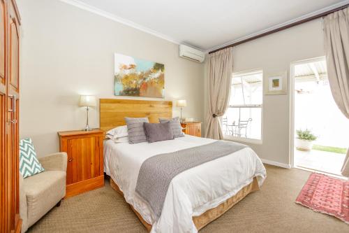 1 dormitorio con 1 cama, 1 silla y 1 ventana en The Ashford en Johannesburgo
