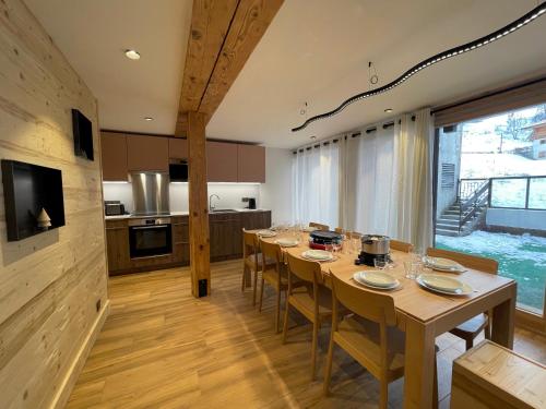 une cuisine et une salle à manger avec une table et des chaises dans l'établissement GRANDE OURSE bel appartement village et pistes, à La Clusaz