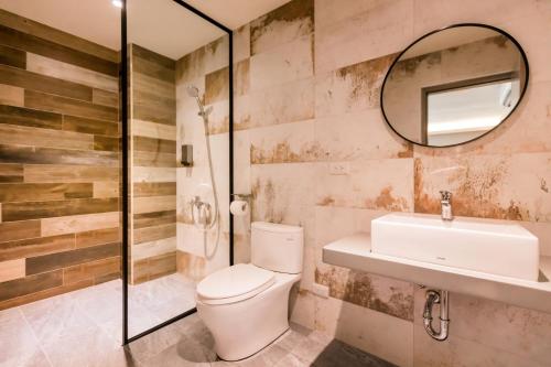 a bathroom with a toilet and a sink and a mirror at Zhudeng 1965 Hotel in Green Island