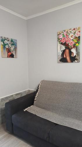 - un lit dans une chambre avec 2 photos sur le mur dans l'établissement La nostra casetta, à Albano Laziale