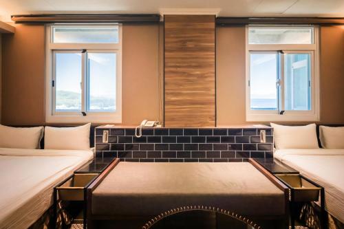 a room with two beds and two windows at Zhudeng 1965 Hotel in Green Island
