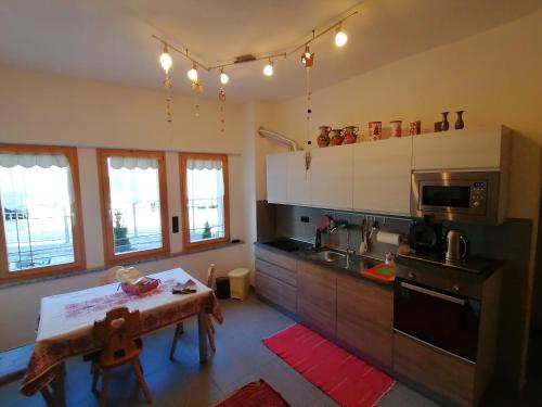 eine Küche mit einem Tisch, einer Spüle und einem Herd in der Unterkunft Villa Alessandra in Gossensaß