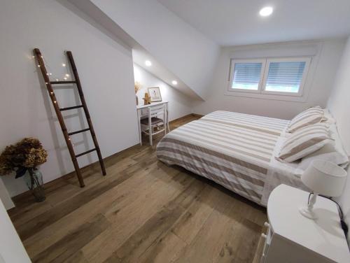 Habitación pequeña con cama y escalera en Casa Jardin Vigo, en Vigo