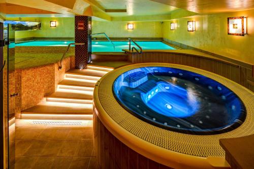 a jacuzzi tub in a room with two swimming pools at David Wellness Hotel in Harrachov