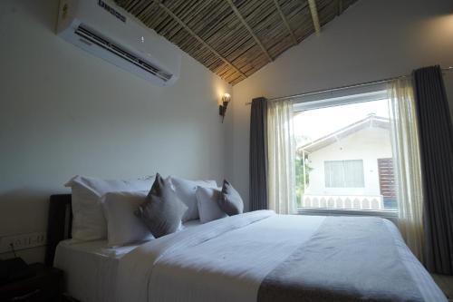 1 dormitorio con cama blanca y ventana en Amar Bagh Resort, en Pushkar