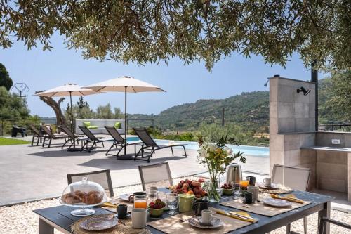 a table with food on top of a patio at 3 Bedroom Modern Villa, Pool, Savoca, East Sicily in Casalvecchio Siculo