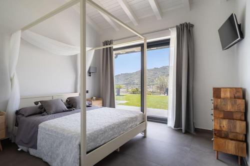 una camera con un letto e una grande finestra di 3 Bedroom Modern Villa, Pool, Savoca, East Sicily a Casalvecchio Siculo