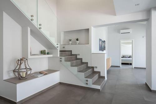 a staircase in a living room with white walls at 3 Bedroom Modern Villa, Pool, Savoca, East Sicily in Casalvecchio Siculo