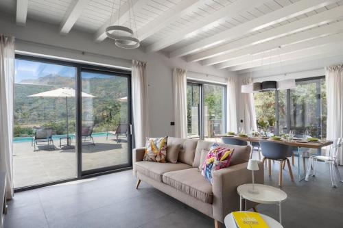 a living room with a couch and a table at 3 Bedroom Modern Villa, Pool, Savoca, East Sicily in Casalvecchio Siculo