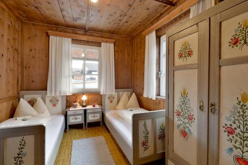 a small room with two beds and a window at Hanserhof in Fügen