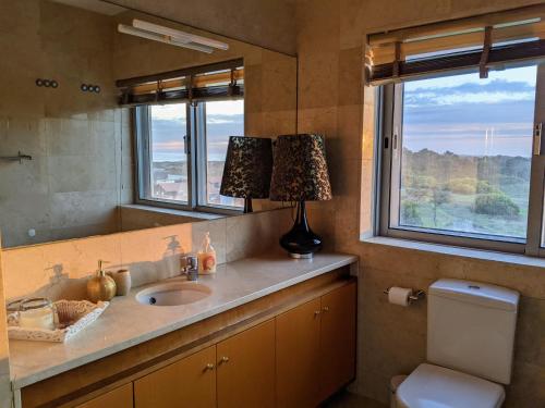 een badkamer met een wastafel en een spiegel bij Duplex by the Beach in Ovar