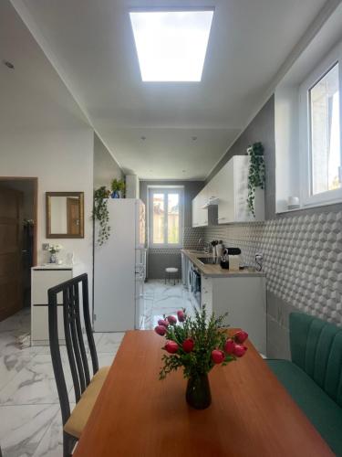 une cuisine avec une table en bois et un vase de fleurs. dans l'établissement Nice Libération, à Nice