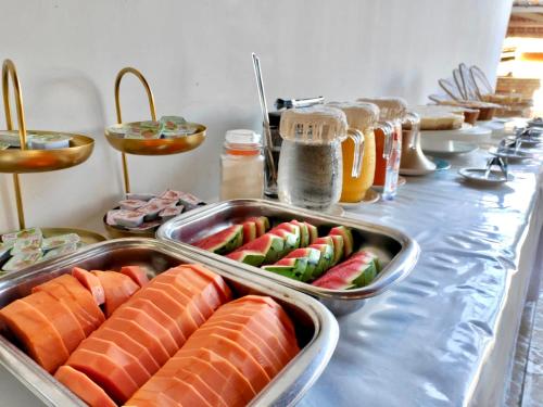 a buffet of food with salmon and watermelon and honey at Pousada Hippopotamus Jeri in Jericoacoara