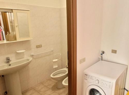 uma casa de banho com um WC e uma máquina de lavar roupa em Authentic mountain house in Barzio center em Barzio