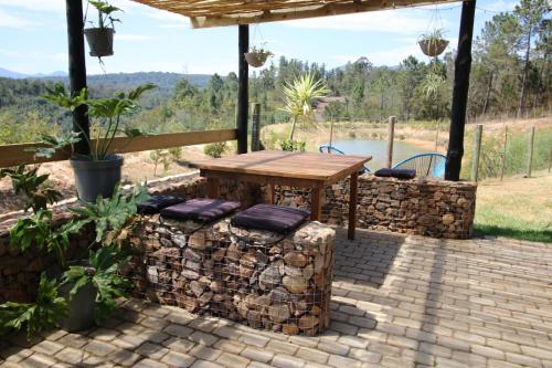 a patio with a wooden table and stools at The Wild Edge First Light Cottage in Knysna
