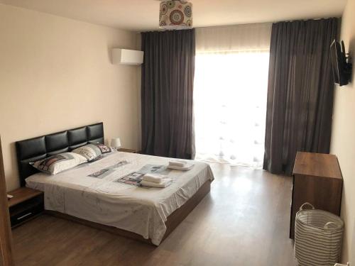 a bedroom with a bed and a large window at City Apartments 2 in Pazardzhik