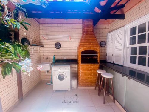 a kitchen with a washing machine in a brick wall at Casa Vila da Praia Buzios - Centro in Búzios