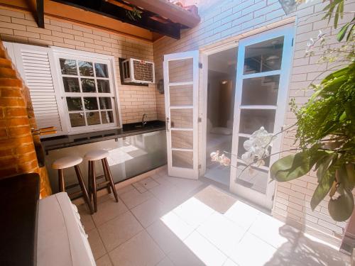 a kitchen with a door and a counter with stools at Casa Vila da Praia Buzios - Centro in Búzios