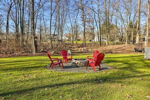 four red chairs sitting around a fire pit in a park at New Paltz Apt - 11 Mi to Poughkeepsie! in New Paltz
