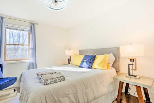 1 dormitorio con 1 cama con almohadas amarillas y azules en New Paltz Apt - 11 Mi to Poughkeepsie! en New Paltz