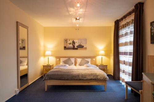 a hotel room with a bed and a mirror at Servus Gelting in Geretsried