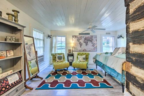 - une chambre avec un lit et deux chaises dans l'établissement Historic Marshall Log Cabin Less Than 1 Mi to Dtwn!, à Marshall