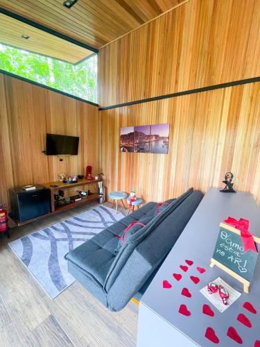 a living room with a couch and a flat screen tv at Pousada Sitio Raizes in Siderópolis