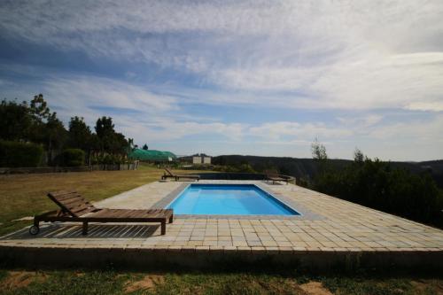 a swimming pool with a bench and a table at The Wild Edge First Light Cottage in Knysna