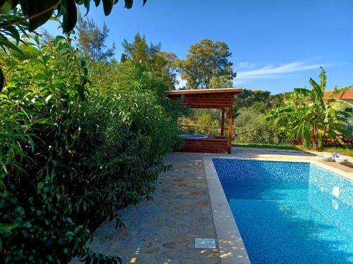 a swimming pool with a gazebo in a yard at Alegria Villas Complex in Vasilikos
