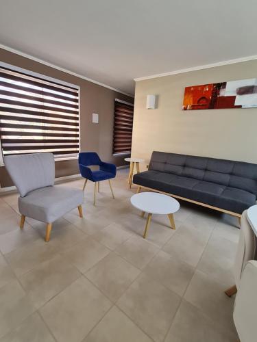 a living room with a blue couch and chairs at Cabañas y Loft Parronal in Vicuña