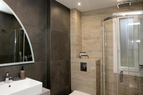 een badkamer met een wastafel en een douche bij Steleni Seaside Apartments in Iraklitsa