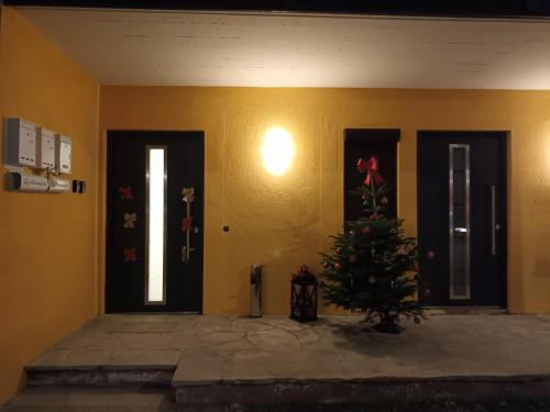 a room with a christmas tree in front of doors at Ferienwohnung Rainer in Fieberbrunn