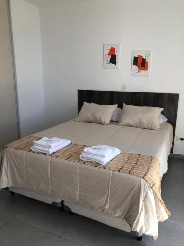 1 cama grande con 2 toallas encima en Comodo Monoambiente en puerto madryn, en Puerto Madryn