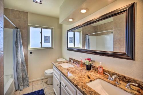 a bathroom with a sink and a toilet and a mirror at Breeze By the Pool Retreat with Game Room! in Chula Vista