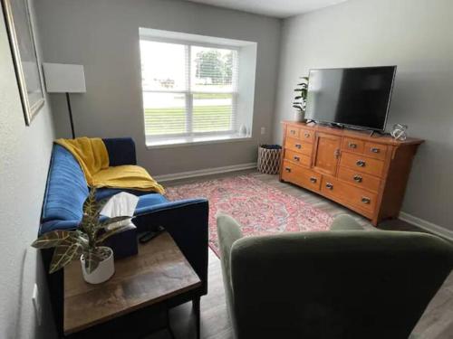 sala de estar con TV, sofá y mesa en The Bernice - 2 Bedroom Apt in Quilt Town, USA, en Hamilton