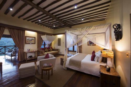 a bedroom with a bed and a living room at Neptune Ngorongoro Luxury Lodge - All Inclusive in Ngorongoro