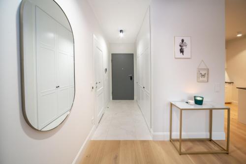 a hallway with a mirror and a table at Maya's Flats & Resorts - River View in Gdańsk