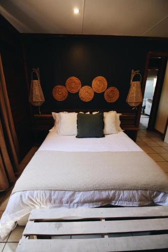 a bedroom with a large bed with a black wall at The Wild Edge First Light Cottage in Knysna